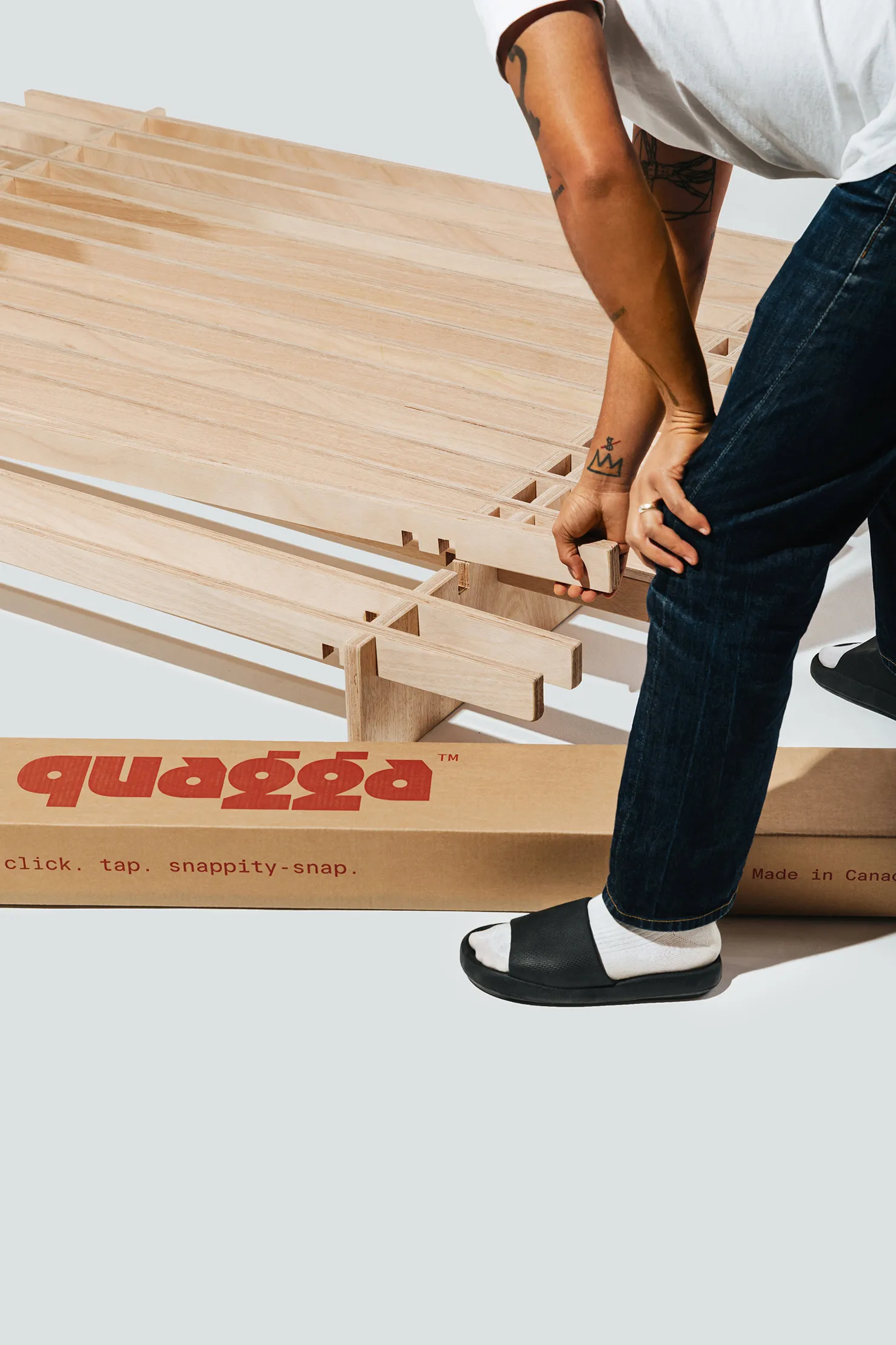 A person building the No Fuss Plus bed frame by Quagga Designs.