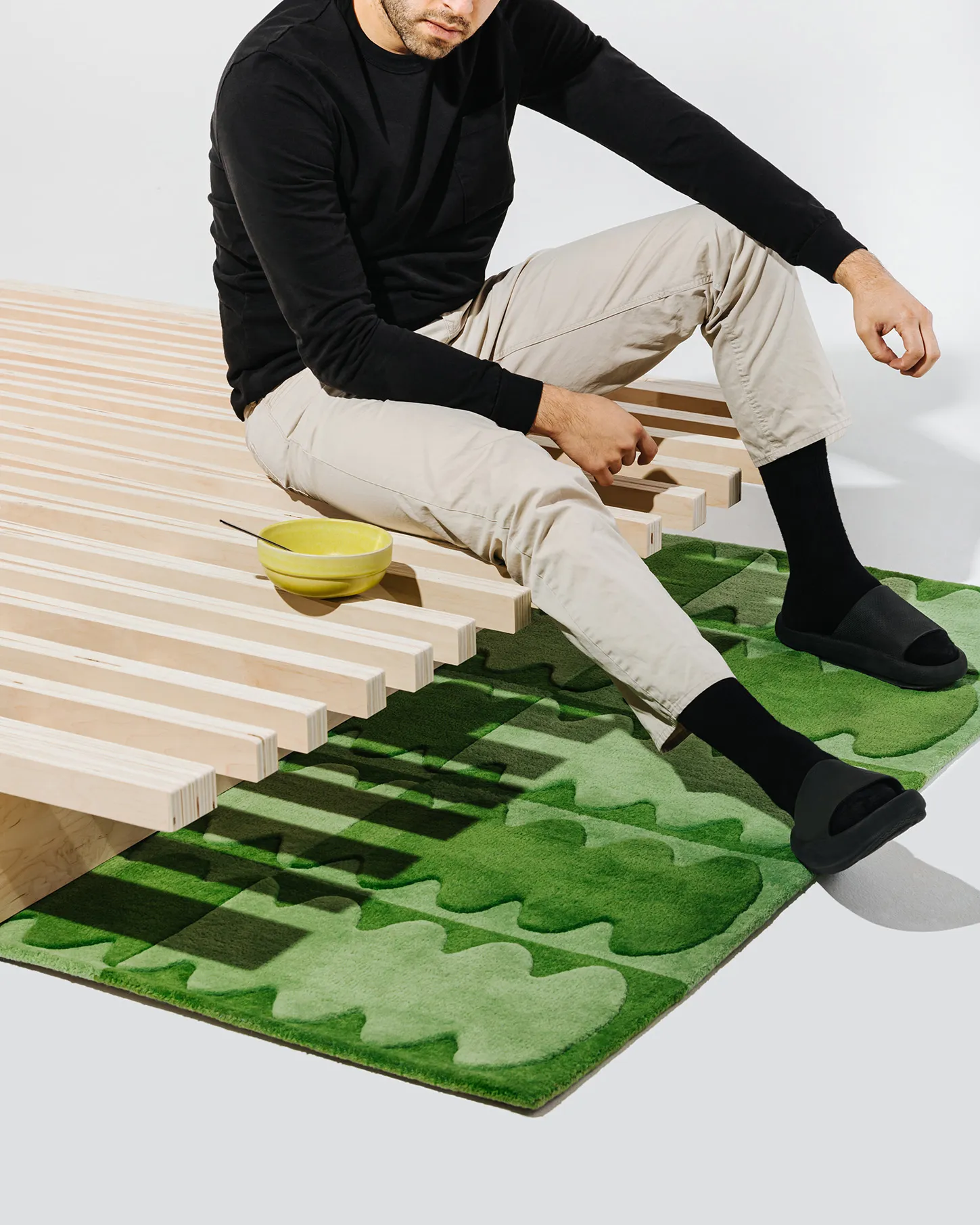 A person sitting on the Accordion bed by Quagga Designs.